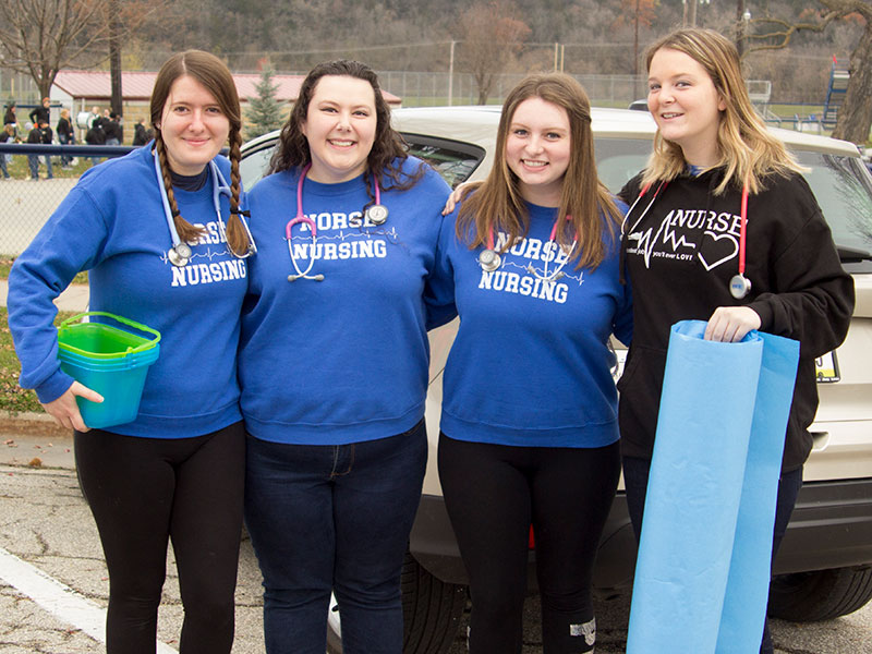 Four students from the Luther College Nurses Association pose for a photo before participating the Homecoming parade