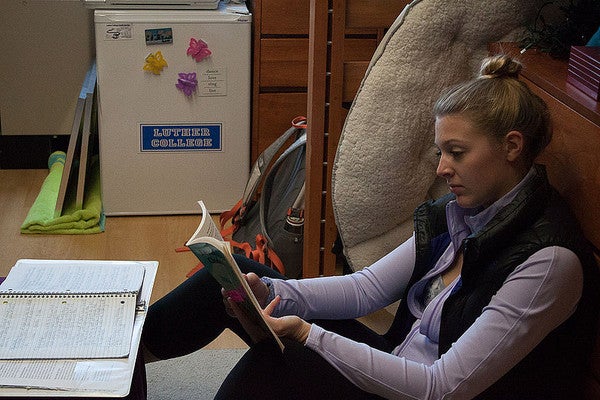 Student sitting on floor reading a book
