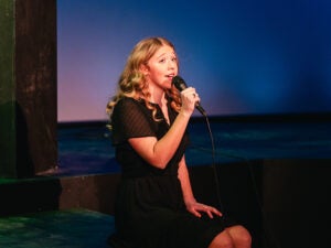 A singer singing into a mic on stage.