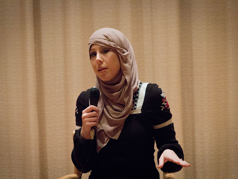 a woman in a hijab speaking into a microphone