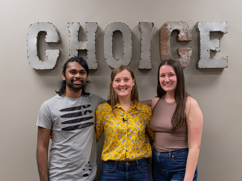 three Luther students standing under a block letter sign that reads Choice