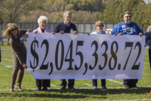 Luther alumni holding a banner with an amount raised by a campaign