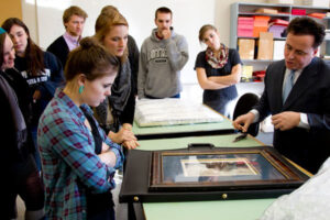 a Luther professor discussing a framed image with students
