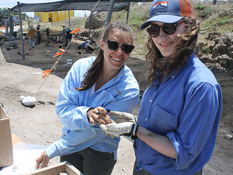 two people outside at an archeological dig site