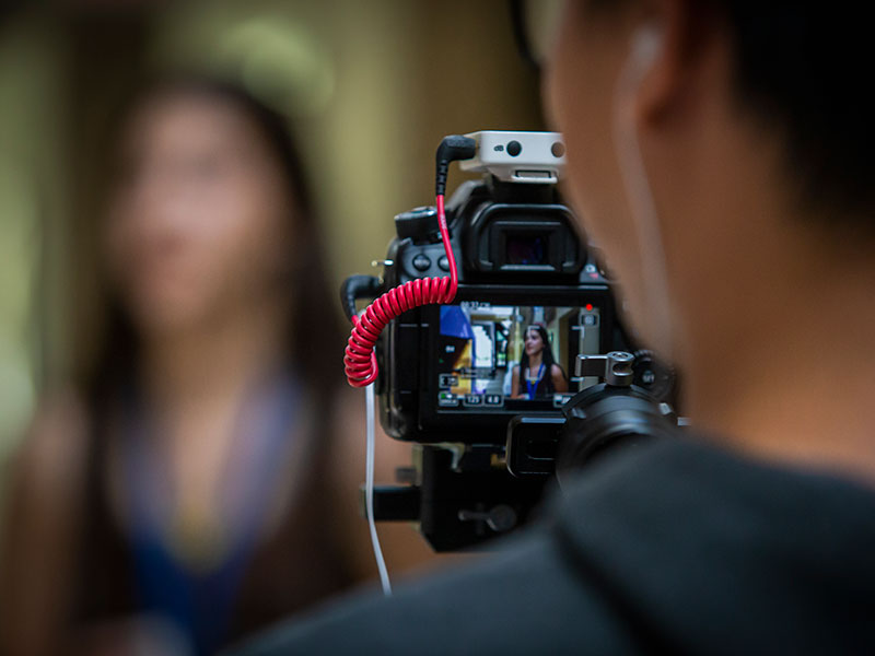 someone holding a video camera, seen from behind