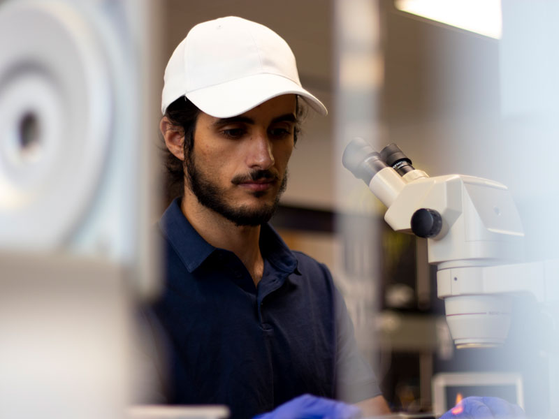 student using a microscope to examine a specimen