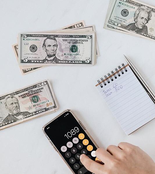 person uses phone calculator to estimate financials