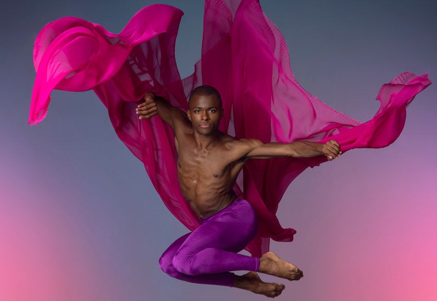 a dancer leaps into the air with billows of fabric