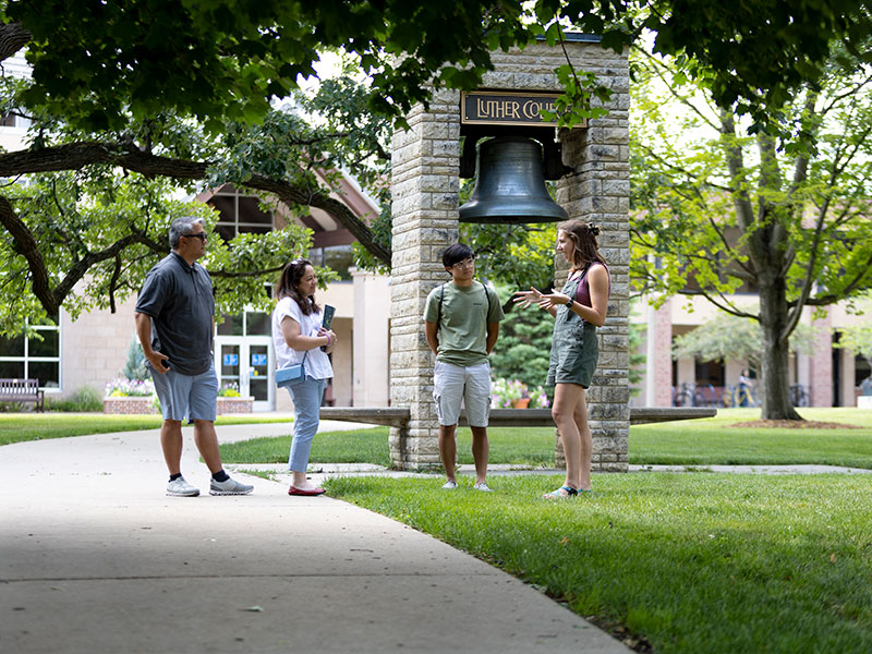 a Luther student giving a tour of campus to a prospective student and his parents