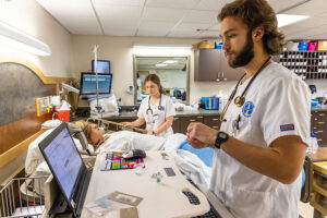 two Luther students attending a dummy patient in the Nursing Simulation Lab