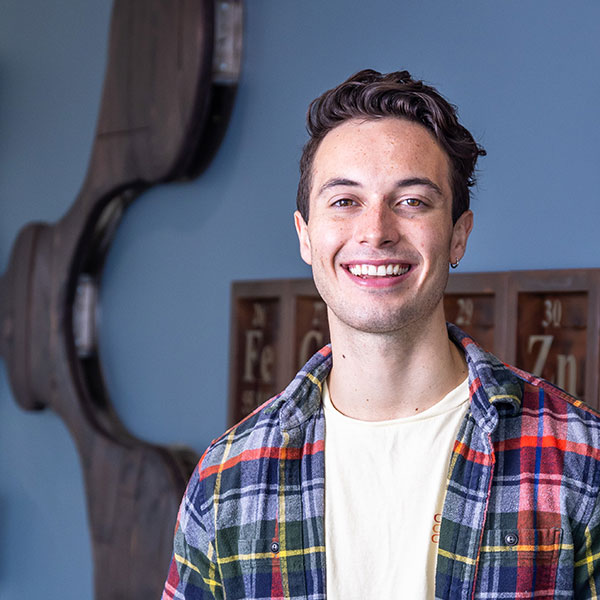 man in plaid shirt smiles at the camera