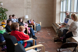 a Luther student reading to a group of young students and parents