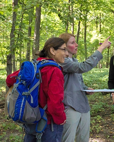 a Luther professor and student having a discussion in one of the natural areas of the Luther campus