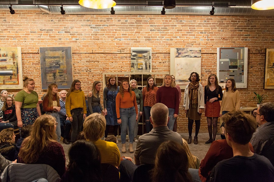a women's choir performing in a small venue