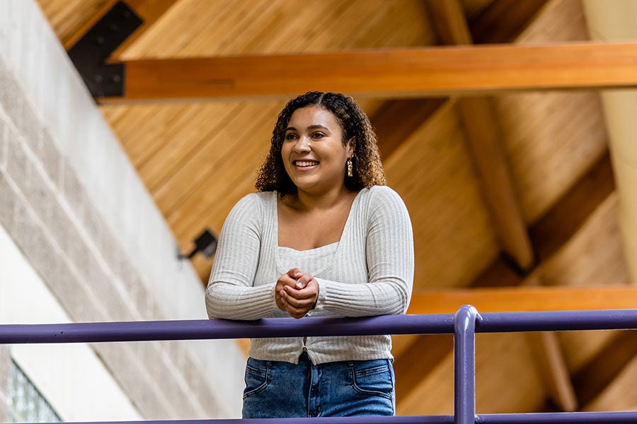 Maya Mukamuri leans against a railing in Jenson-Noble Hall of Music