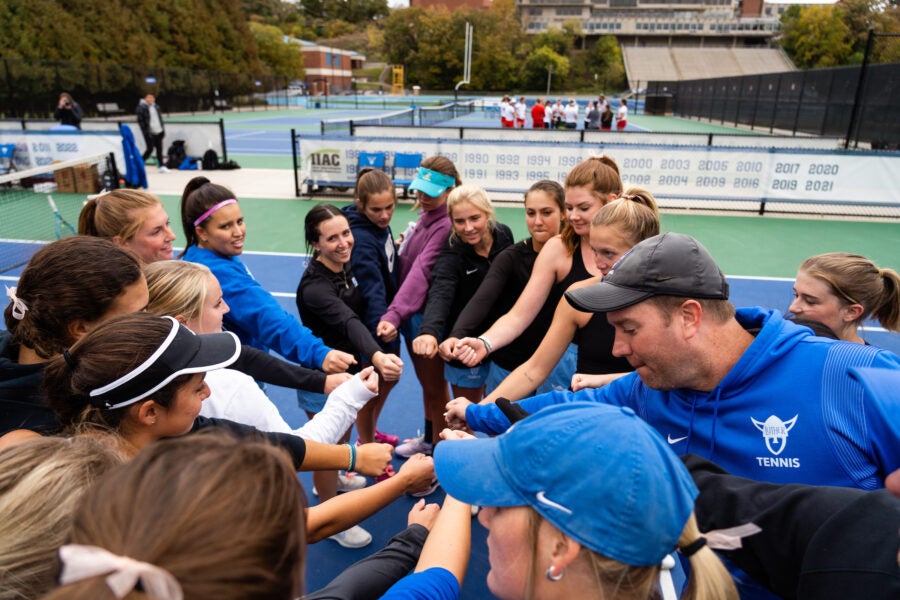 the team gathers in a circle, hands joined