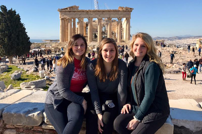 Three students take a picture outside of the Parthenon in Athens, Greece