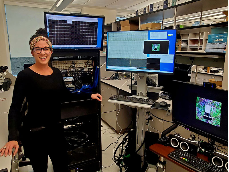 Krista Wahlstrom '15 stands with equipment she uses for neural recordings and memory tasks.