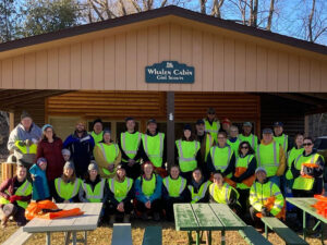 Photo of a large group of APO volunteers in safety vests under a park shelter