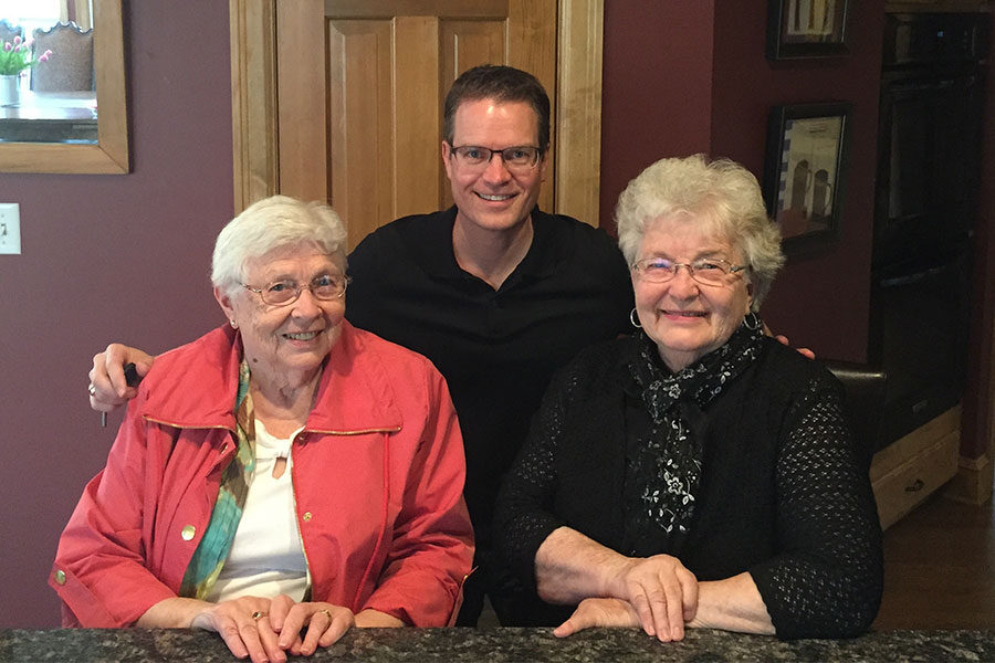 GrandPad founder Scott Lien at a table with an arm around his mother and mother-in-law