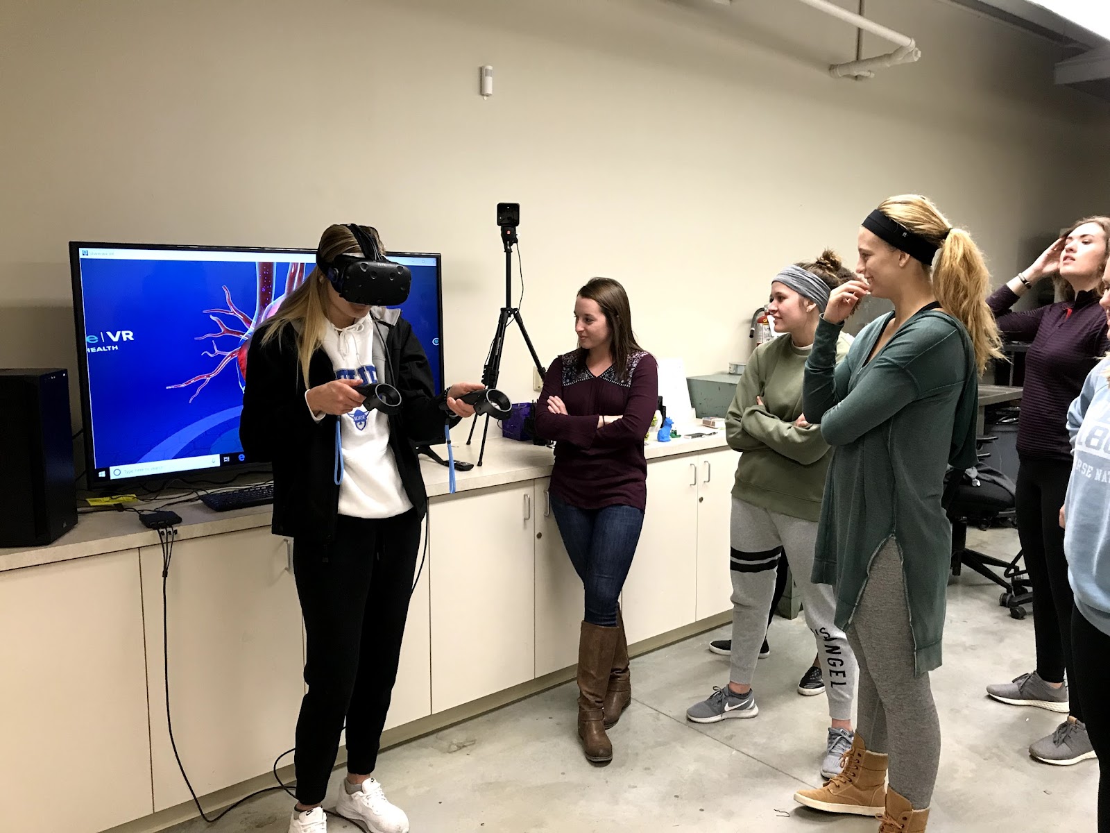 Luther students observe a student using a VR headset to explore the human body and disease.