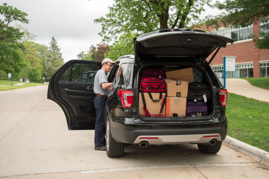 Parent loading the car to help their student move home for the summer.