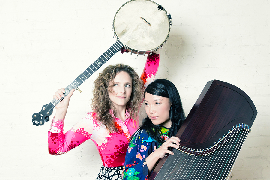 Two female musicians hold a banjo and a zither.