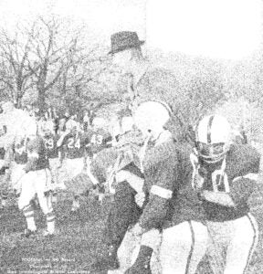 Football team hoisting coach Edsel Schweizer on shoulders.
