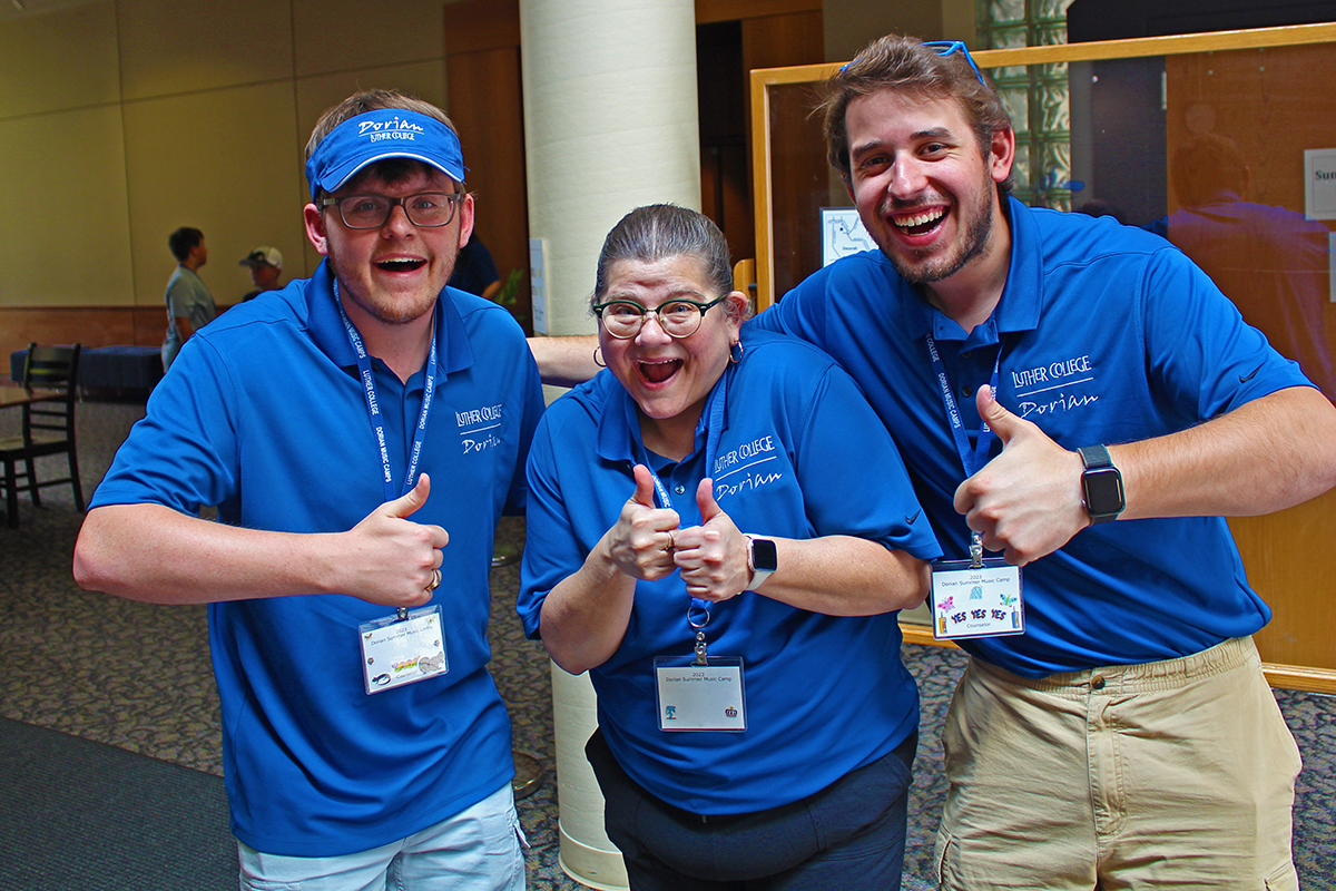 3 Dorian staff members in blue shirts give thumbs up.