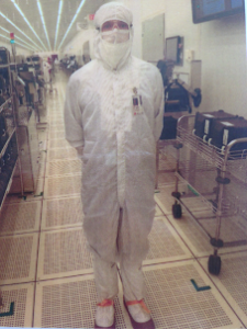 An engineer wearing a full body white cover all standing in a lab