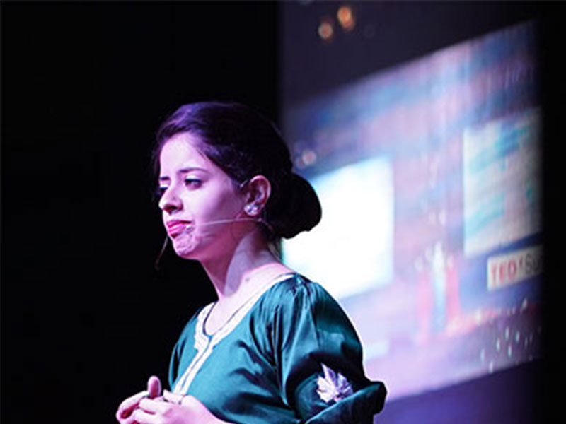A woman on a stage, wearing a headset