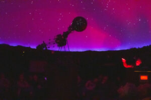 A crowd a people sitting inside the Miller Planetarium