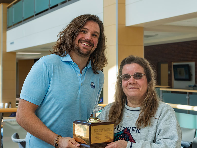 A man and woman hold a trophy