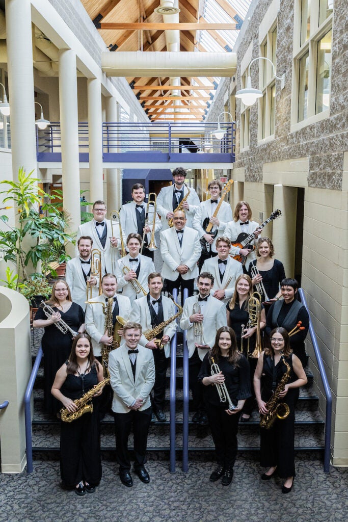 Luther students stain on stairs holding different instruments for group photo.