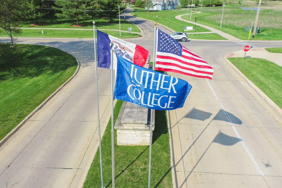 Luther College flag in front of Iowa and American flags.