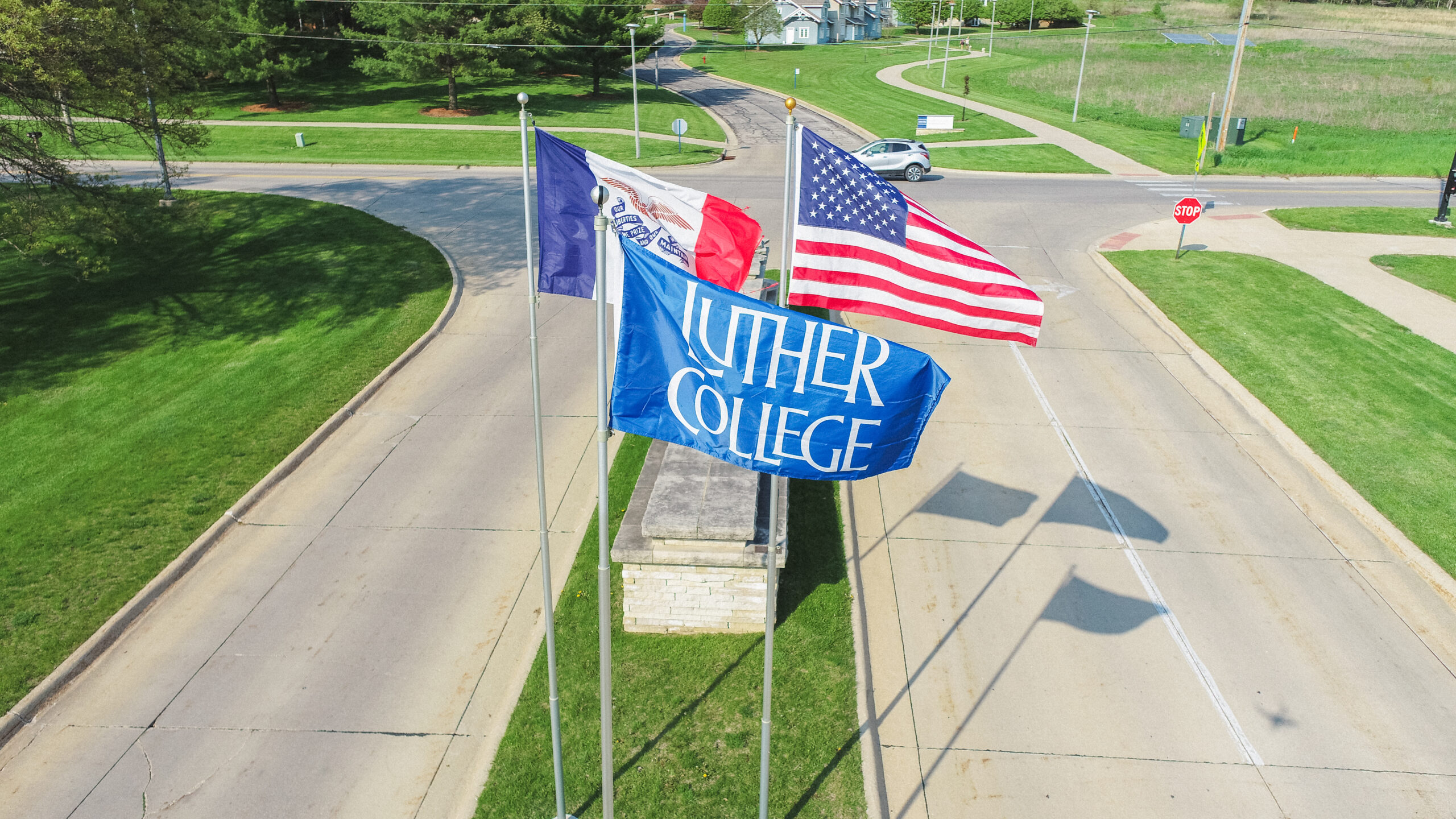 Luther College flag in front of Iowa and American flags.