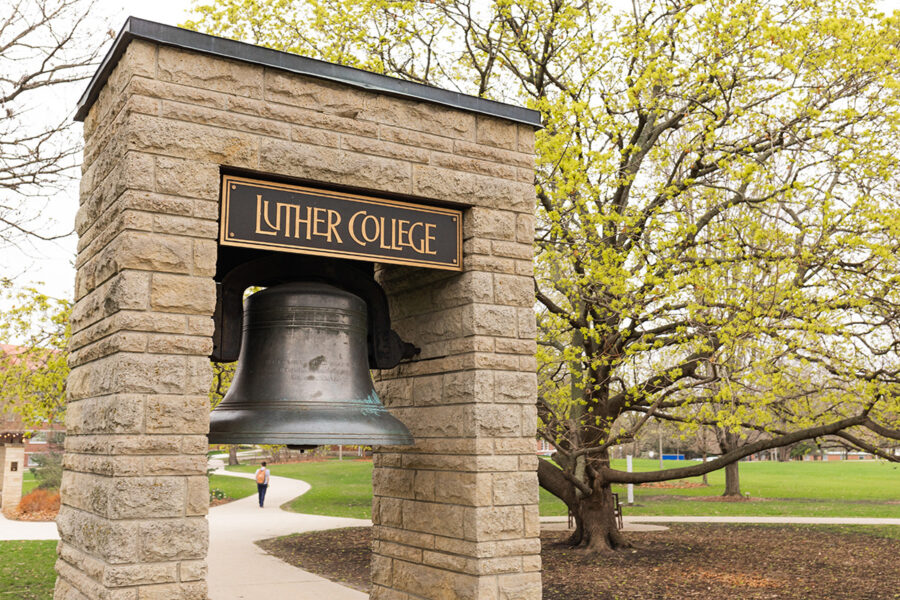 Bell between two stone columns with sign above that says 