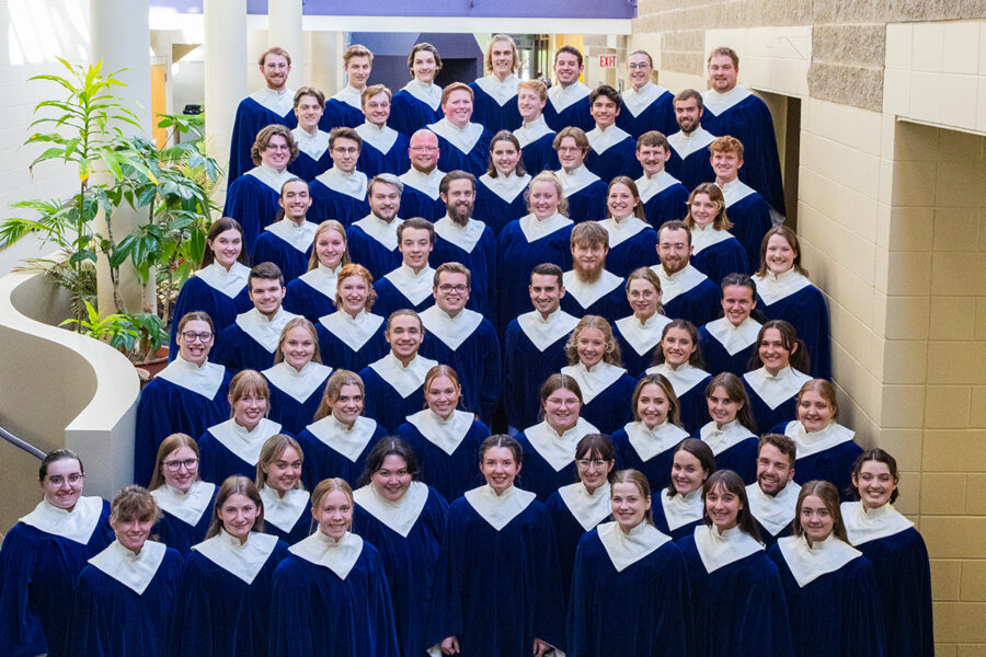Nordic Choir posing on stairs in blue robes for a group photo.