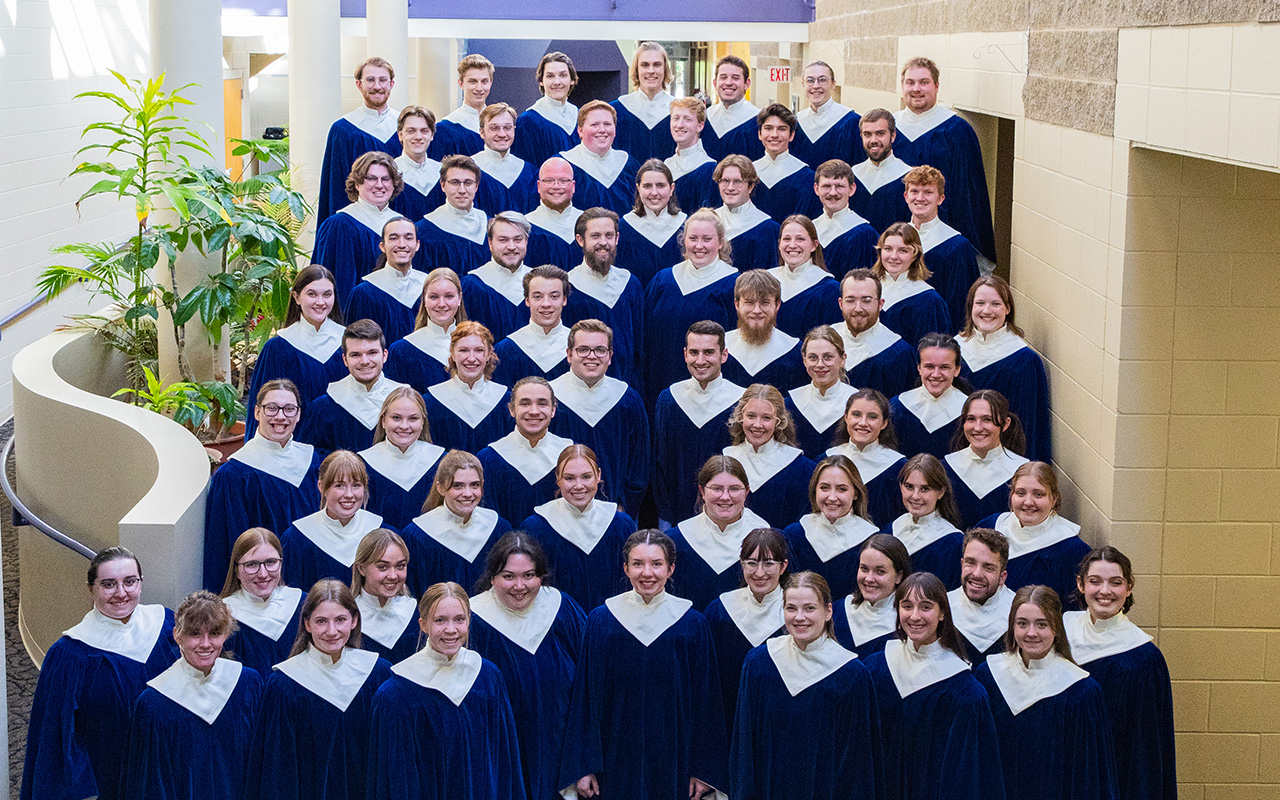 Nordic Choir posing on stairs in blue robes for a group photo.