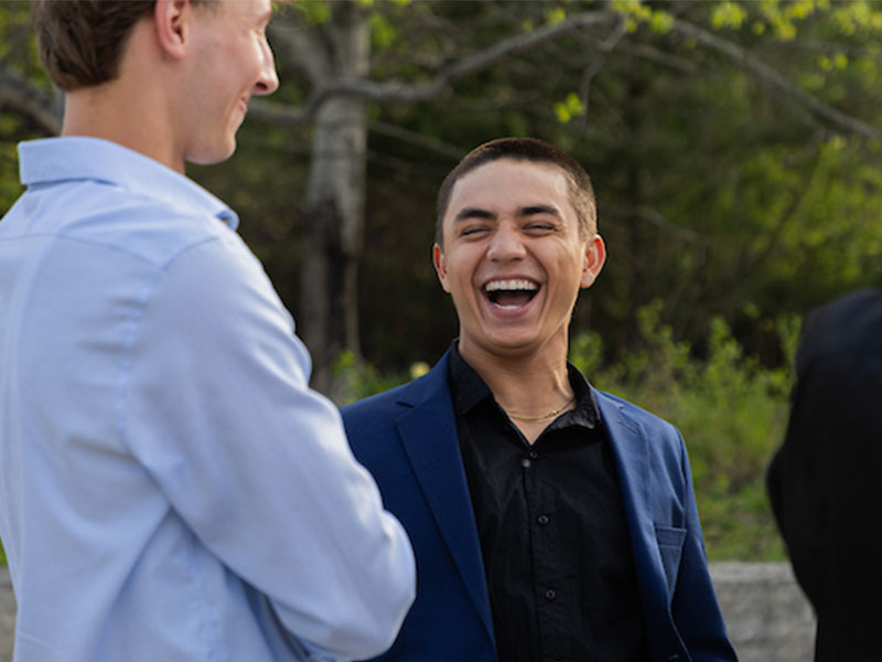 Two young men talking and smiling