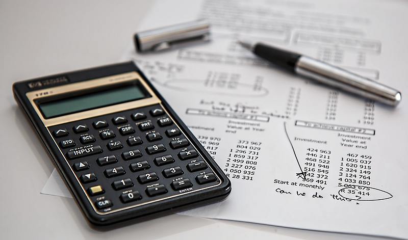 calculator beside paper and pen