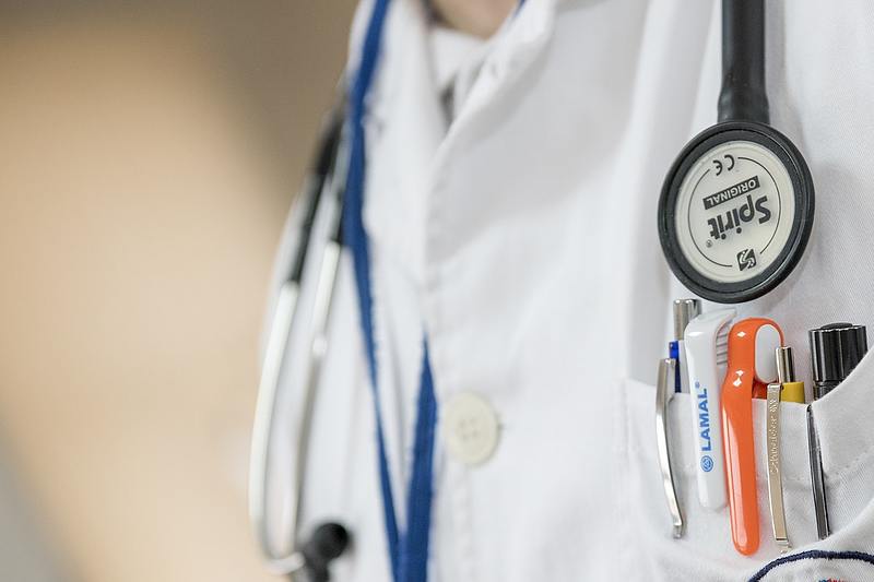 person wearing white lab coat and stethoscope