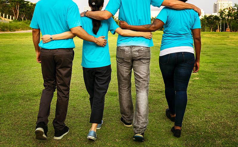 line of four people linking each other together in unity