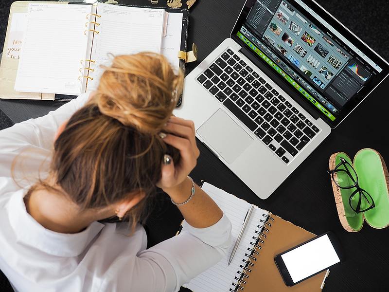 person sits at desk with paper and computer