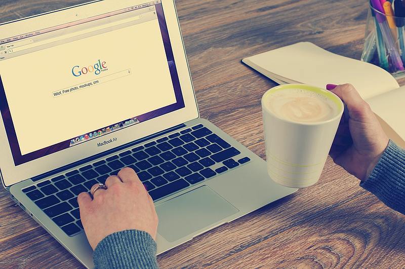 person enjoys a cup of coffee while using web browser google