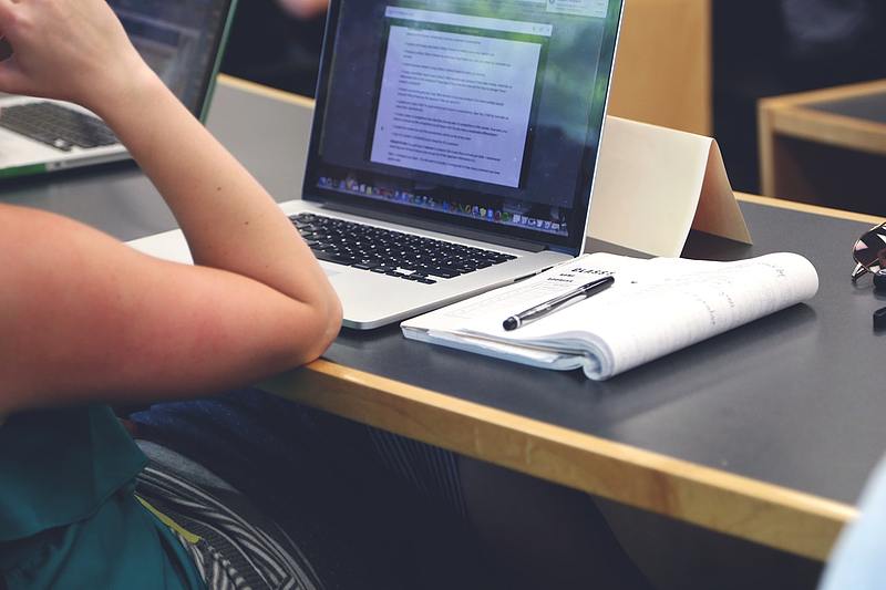 student uses computer to take notes in class