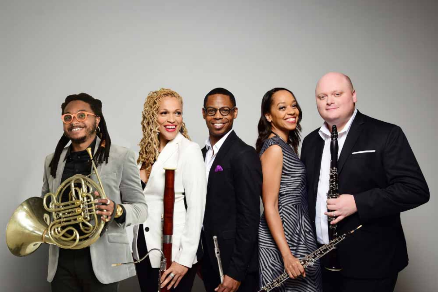 Five person wind ensemble, Imani Winds, holding their intruments