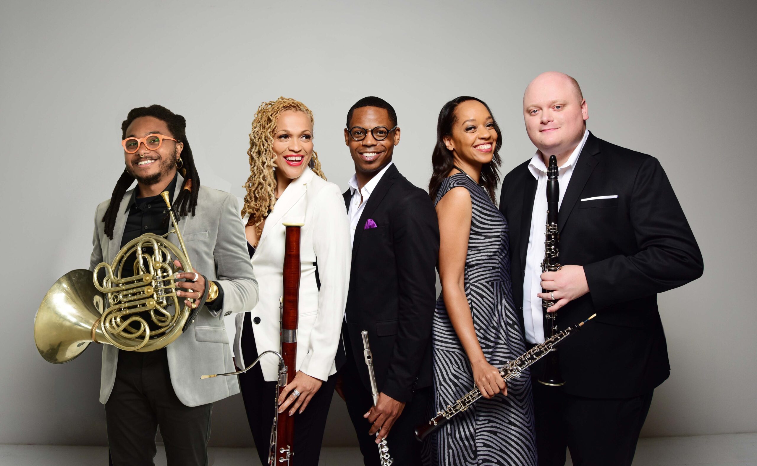 Imani Winds players holding their instruments