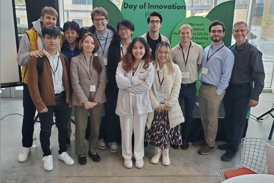A group of 12 people standing in front of a Day of Innovation display