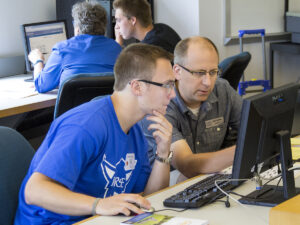 Brad Chamberlain with a student looking at a computer